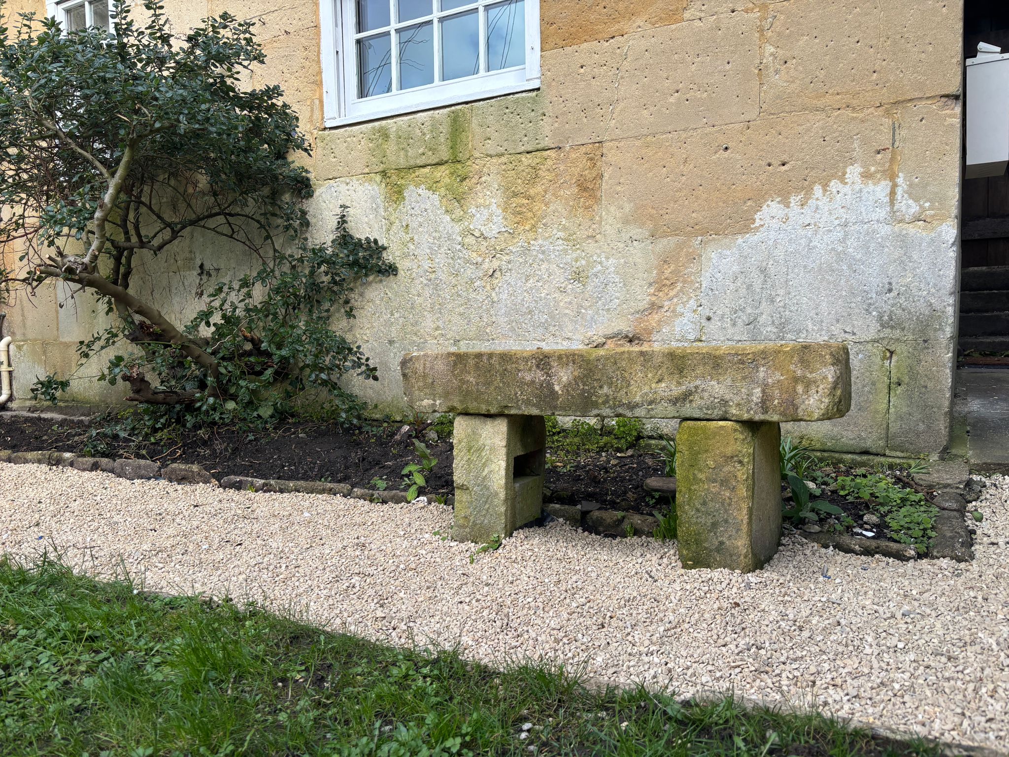 Garden bench beside Bath stone wall